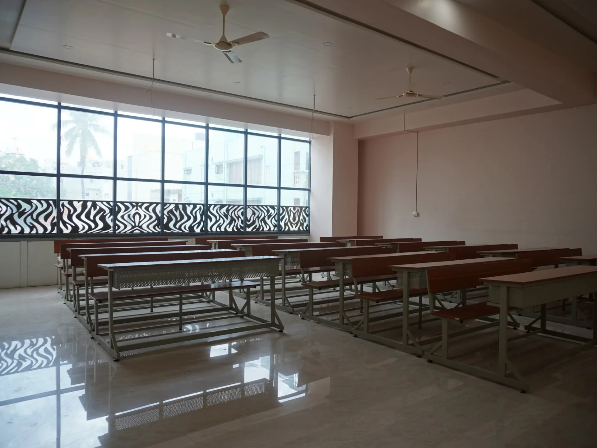 Spacious class room with lecture benches and large windows at Hashmath Pasha Unique College of Law, Bengaluru